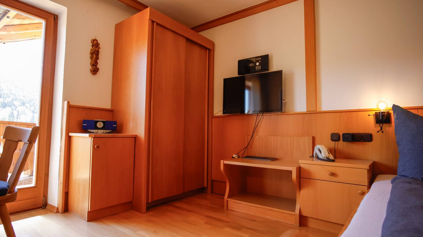 Schrank und TV-Ecke mit Balkontür und Blick auf Hochfelln